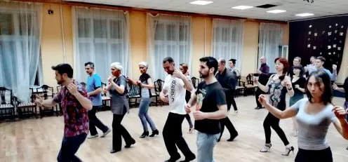 A group tango class with Aaron Benchimol: students practising the steps in a ballroom